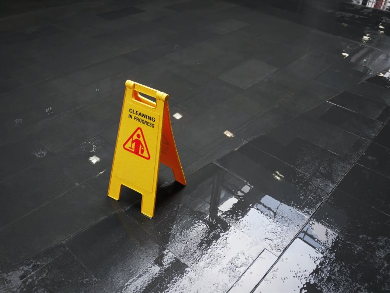 A yellow sign on-wet industrial floor