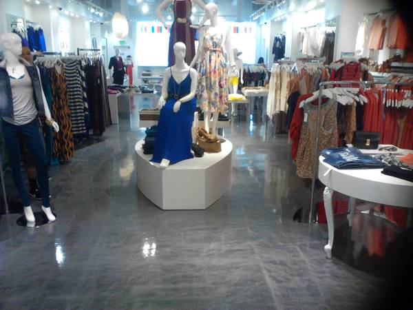 dress shop with mannequins and hanging dresses on racks